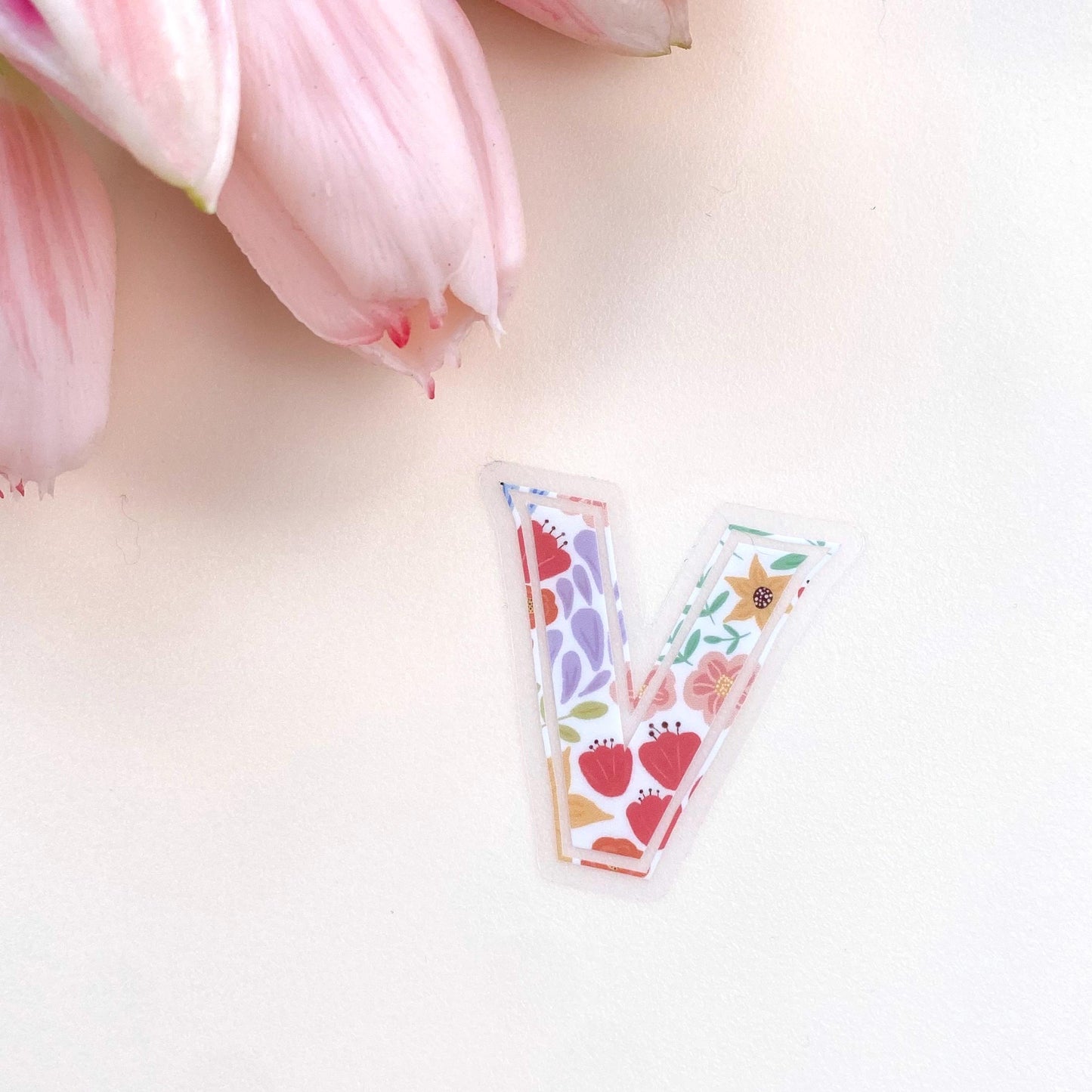 A floral letter 'V' sticker against a white background