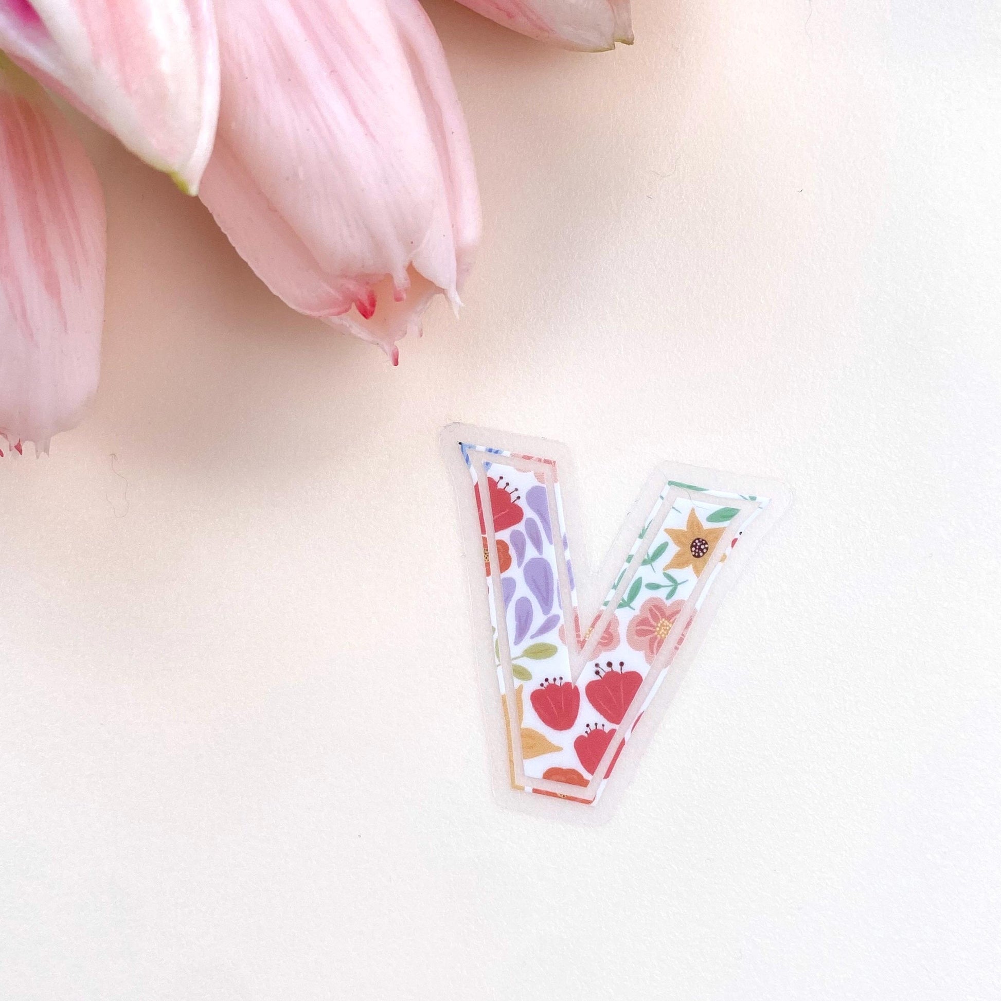 A floral letter 'V' sticker against a white background