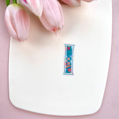 Clear vinyl sticker with a teal floral patterned letter 'I' shown on a white background