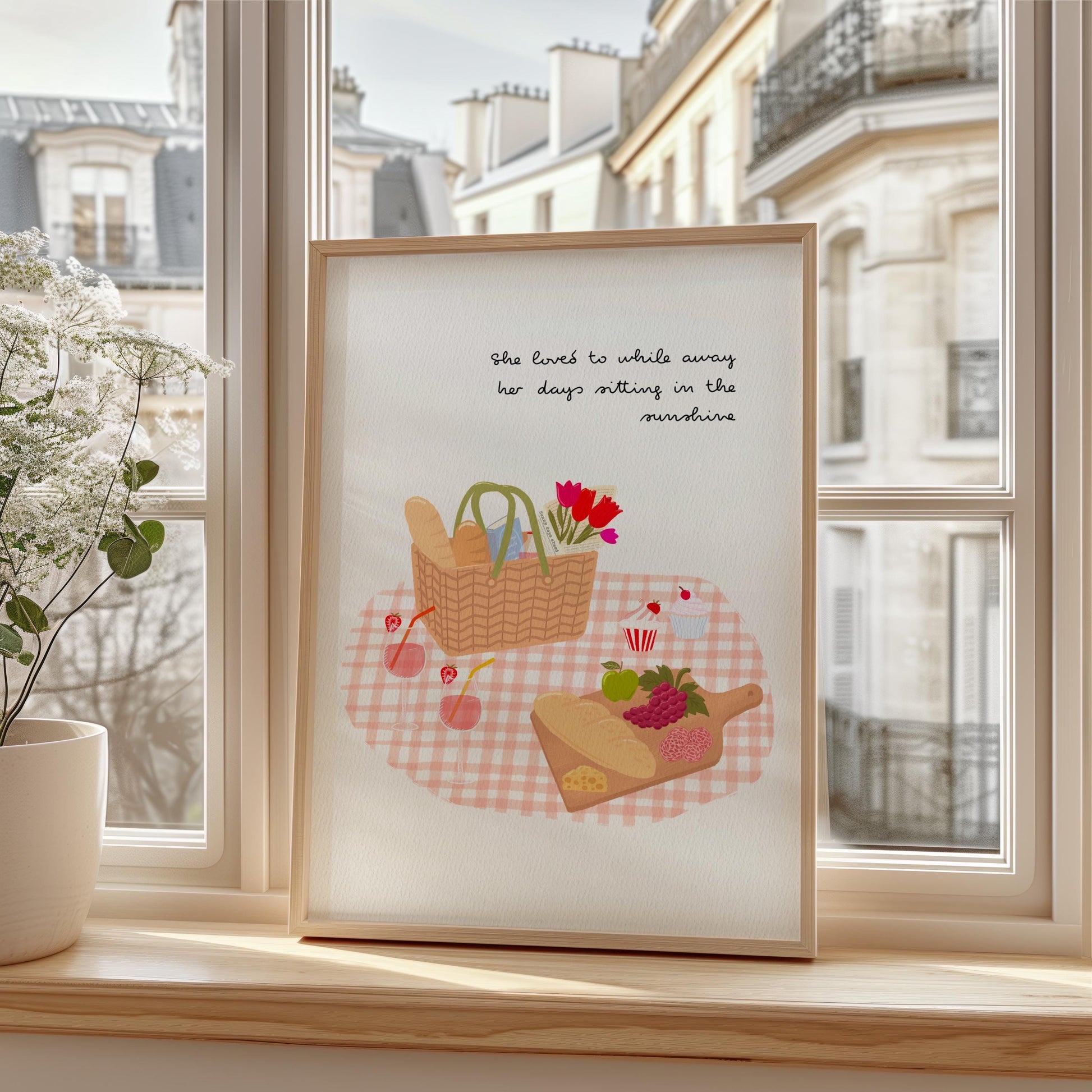 Framed artwork with a picnic scene on a windowsill
