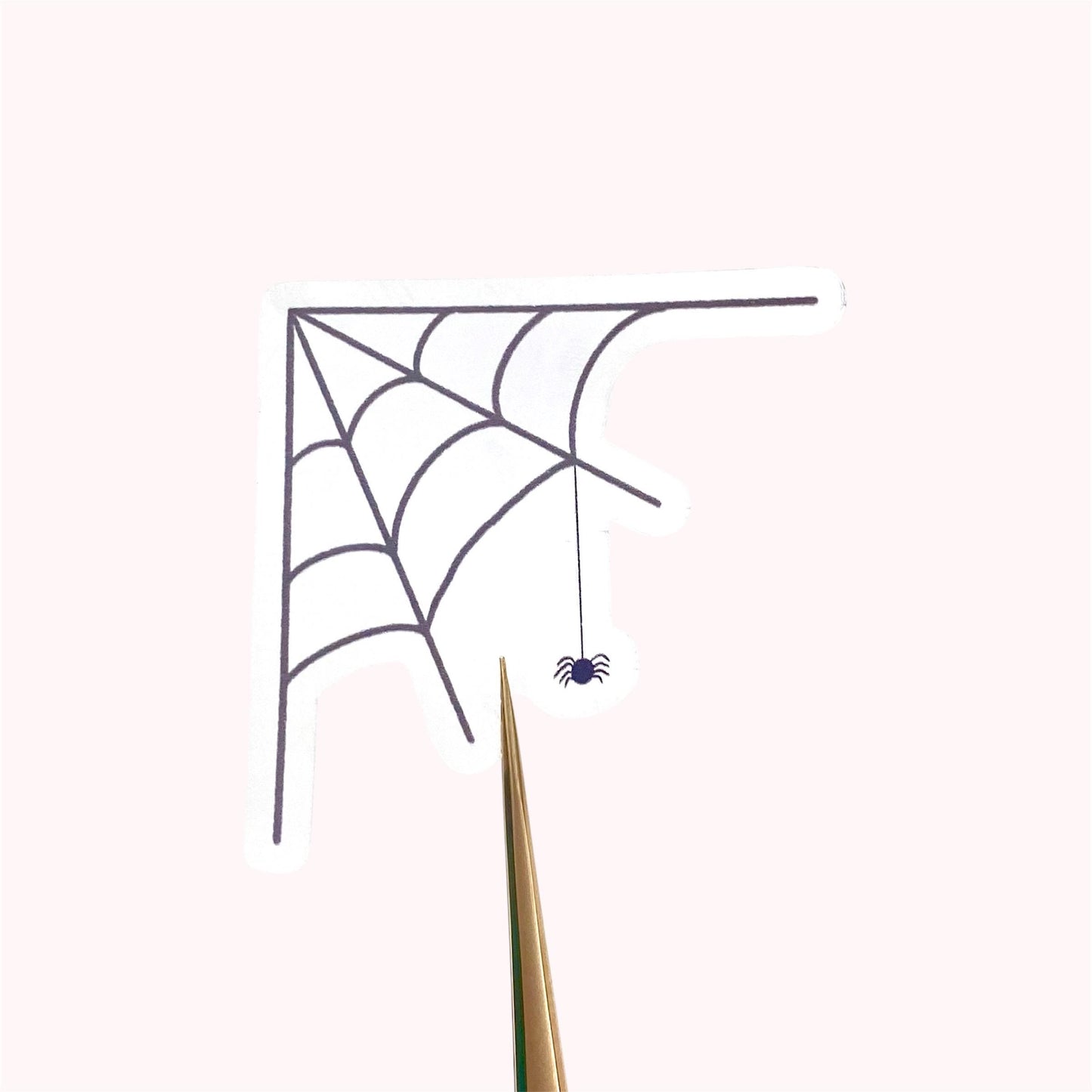 Transparent sticker with corner spider web design with a hanging spider on a white background