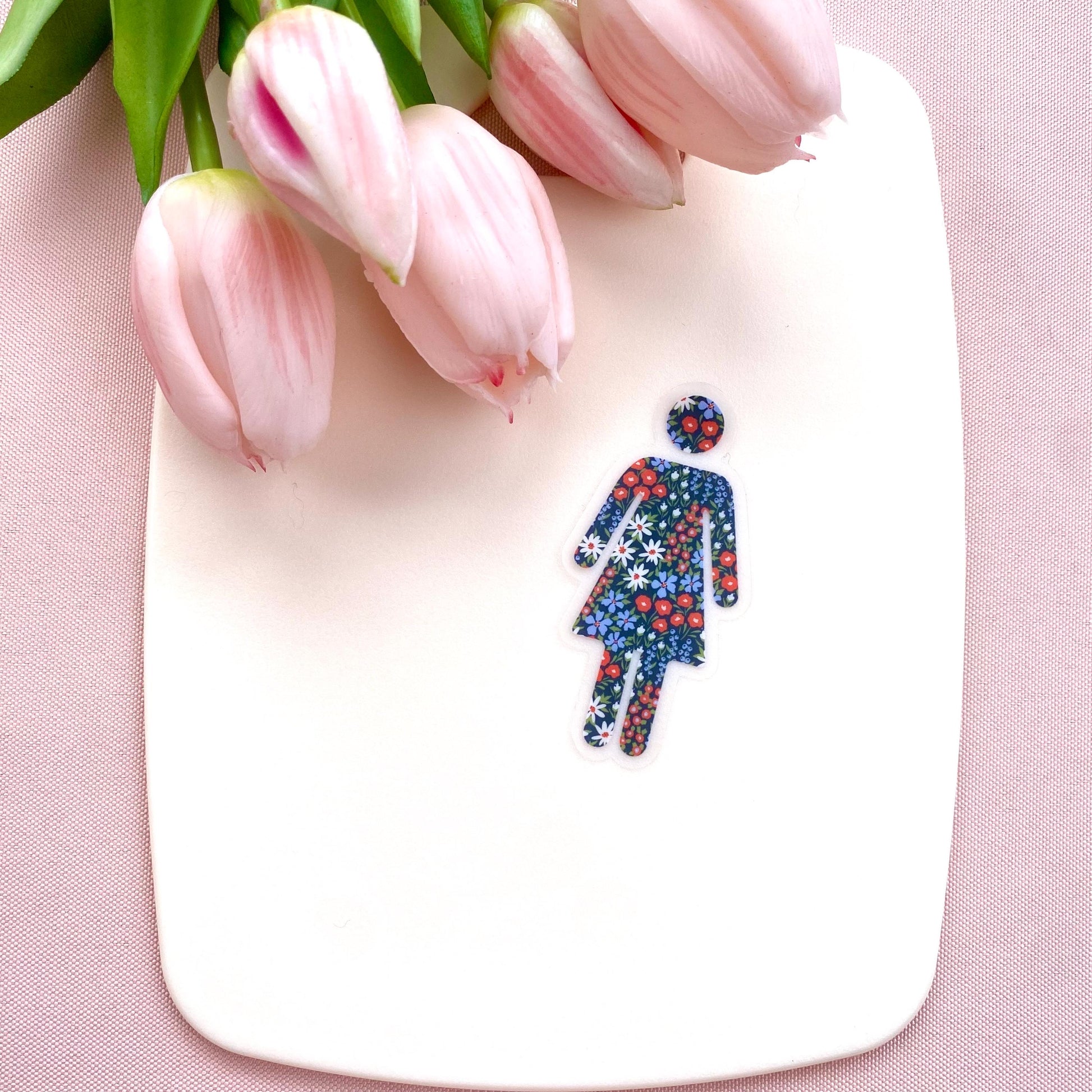 Clear transparent with floral patterned woman silhouette against a cream background with pink tulips.
