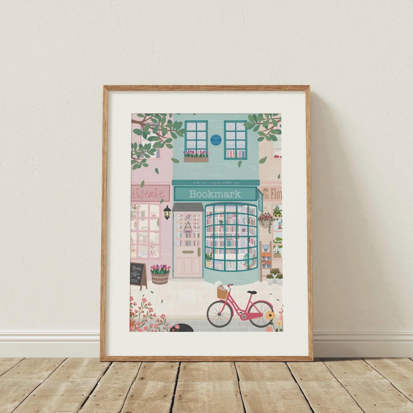 Framed illustration of a quaint bookstore with a pink bicycle on a wooden floor.