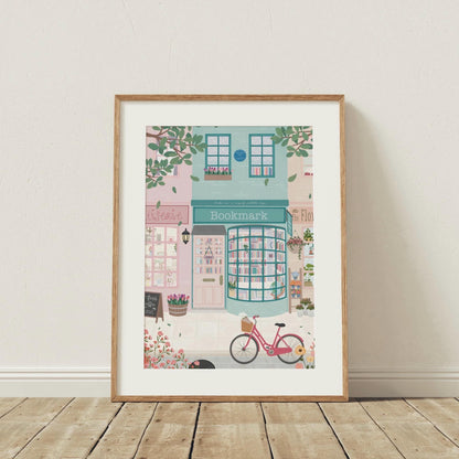 Framed illustration of a quaint bookstore with a pink bicycle on a wooden floor.
