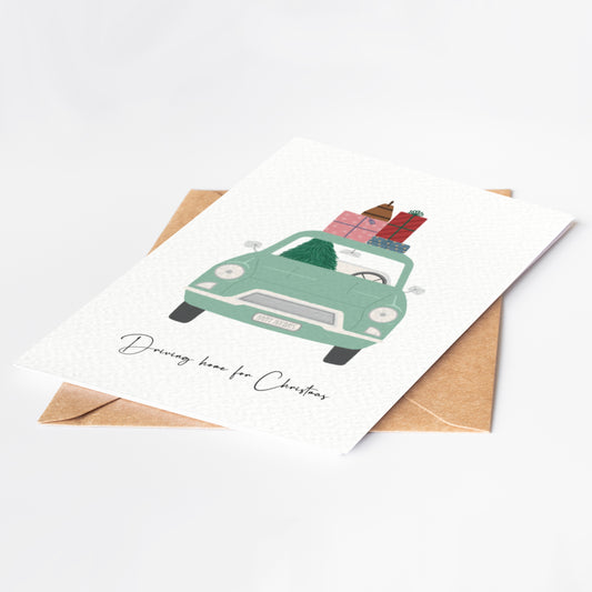 Greeting card with a green car carrying Christmas presents on a white background