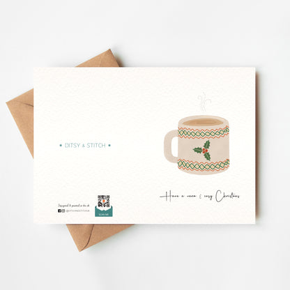 Greeting card with a festive mug illustration and 'Ditsy & Stitch' branding on the back.