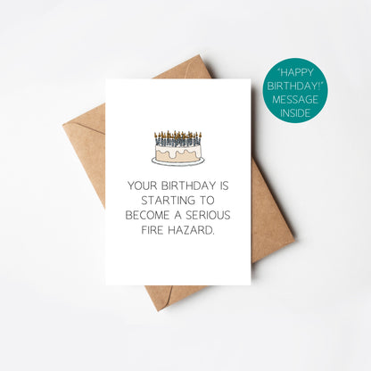 Birthday card with cake illustration and humorous text, accompanied by a brown envelope on a white background.