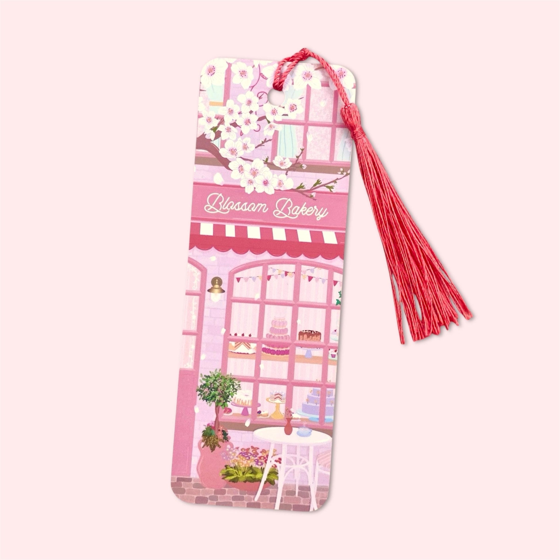 Bookmark with a pink bakery design and bright pink tassel on a light pink background