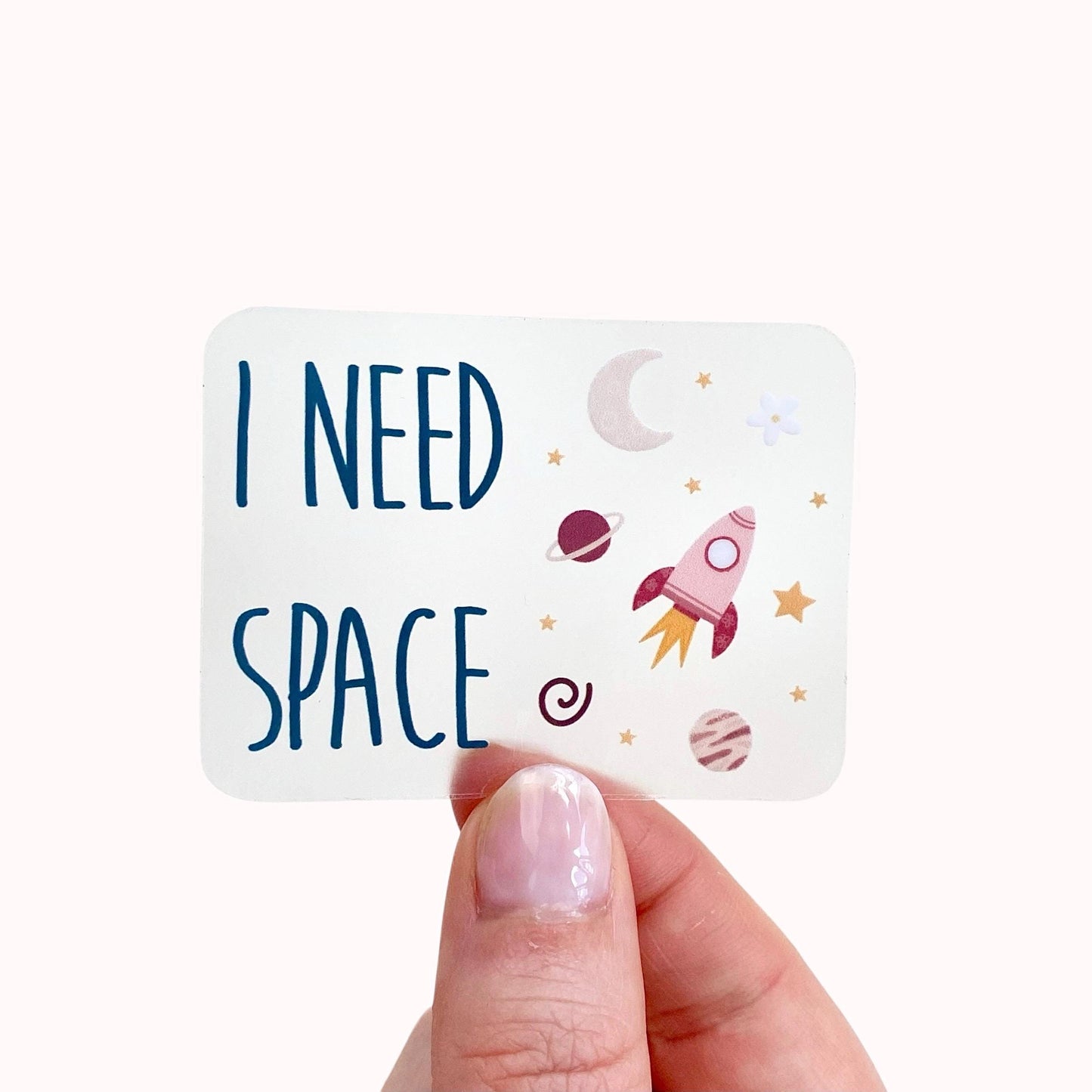 Transparent sticker with 'I Need Space' text and space-themed illustrations held by a hand
