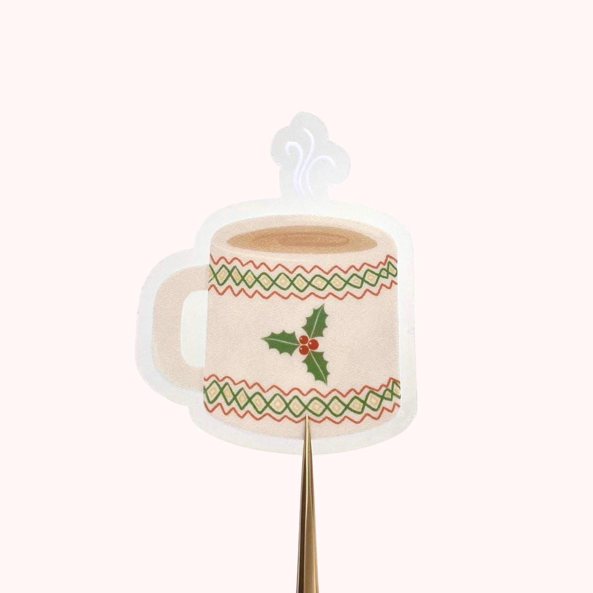 Decorative Christmas sticker shaped like a mug with holly design on a white background