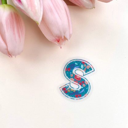 Floral letter 'S' sticker on a light background with pink tulips