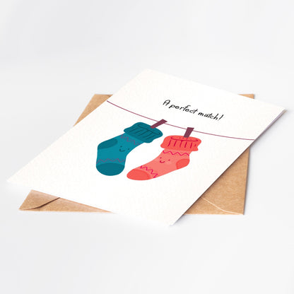 Card with cartoon socks and 'A perfect match!' text on a white background