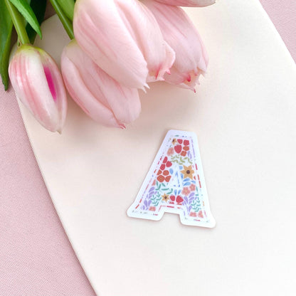 Decorative letter 'A' sticker with floral pattern on a white background with pink tulips.