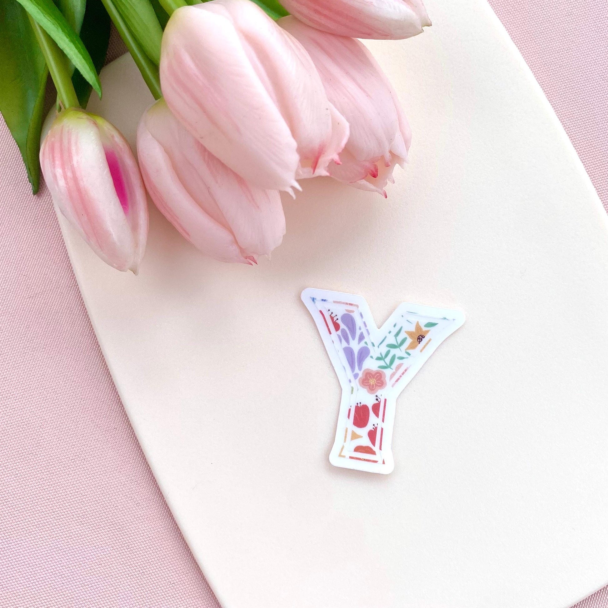 Decorative letter 'Y' sticker with pink tulips on a pink background