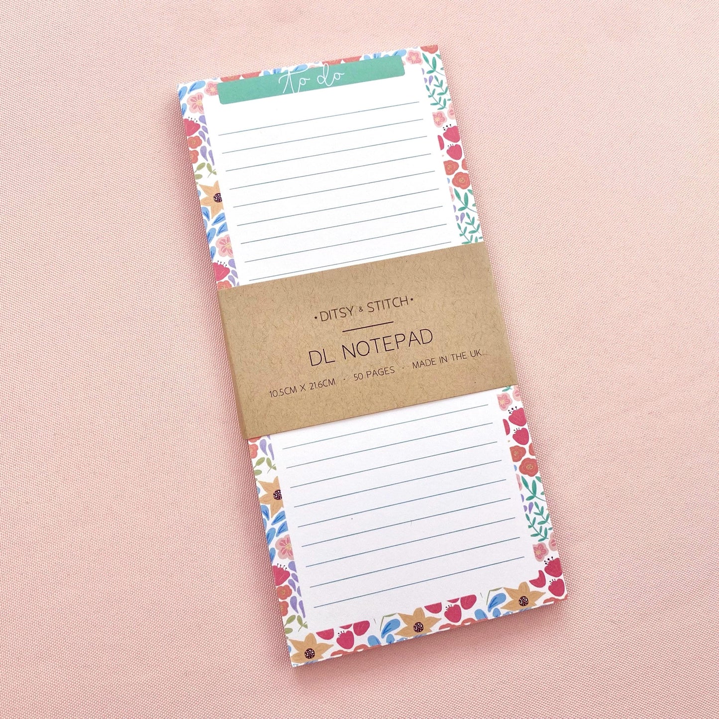 Floral bordered and lined slim notepad on a pink background