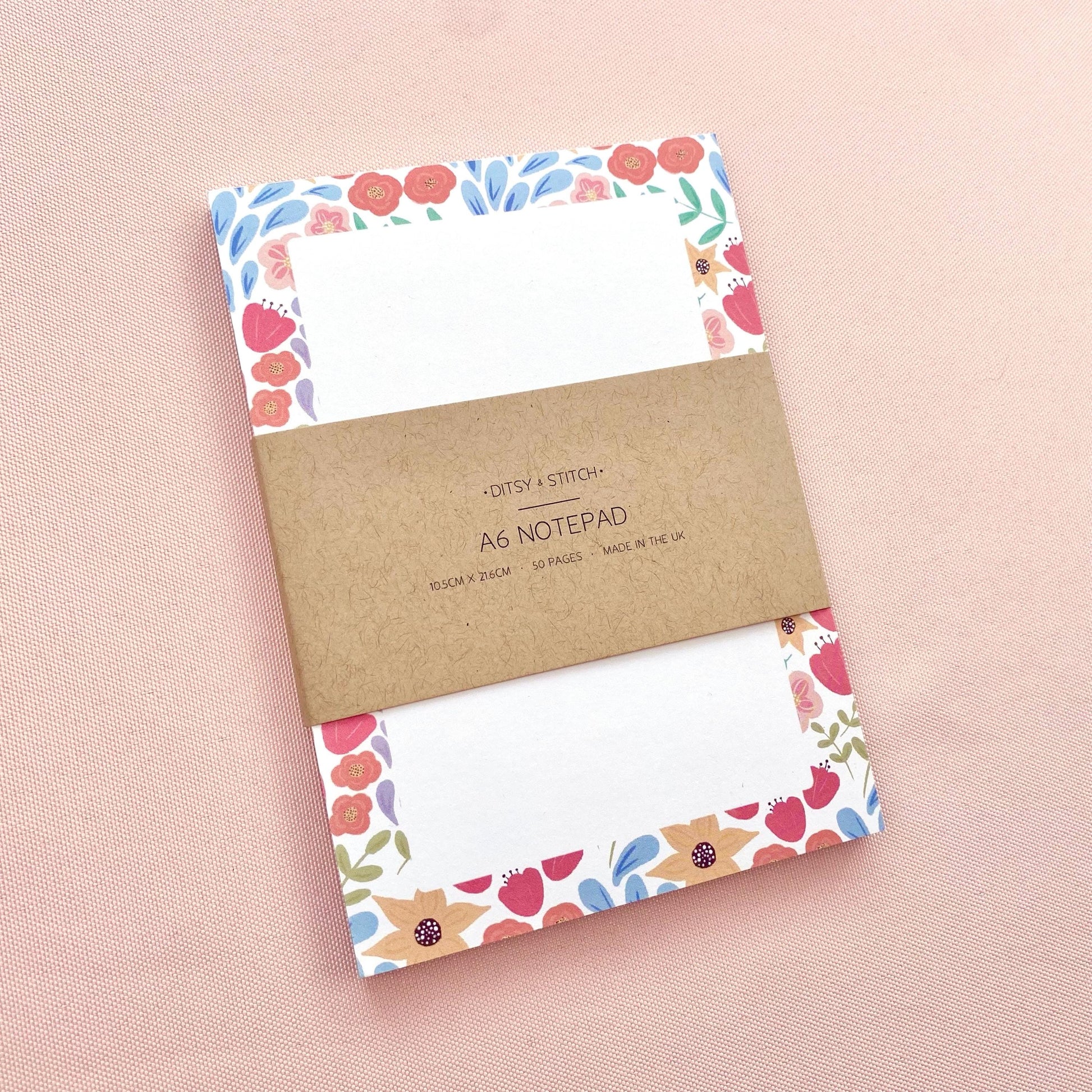 A6 notepad with floral border design on a pink background