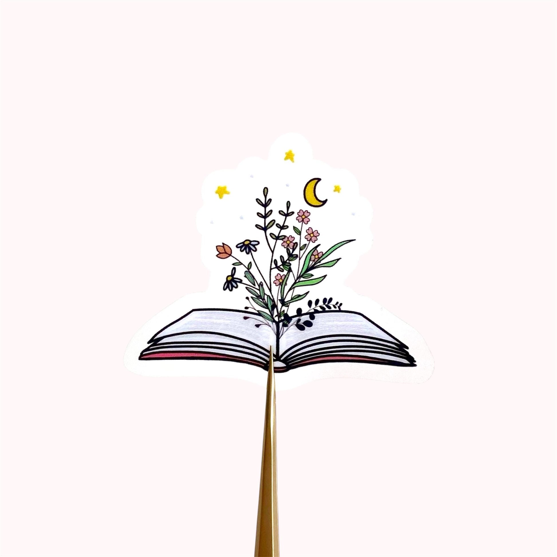 Decorative sticker of an open book with floral designs on a white background