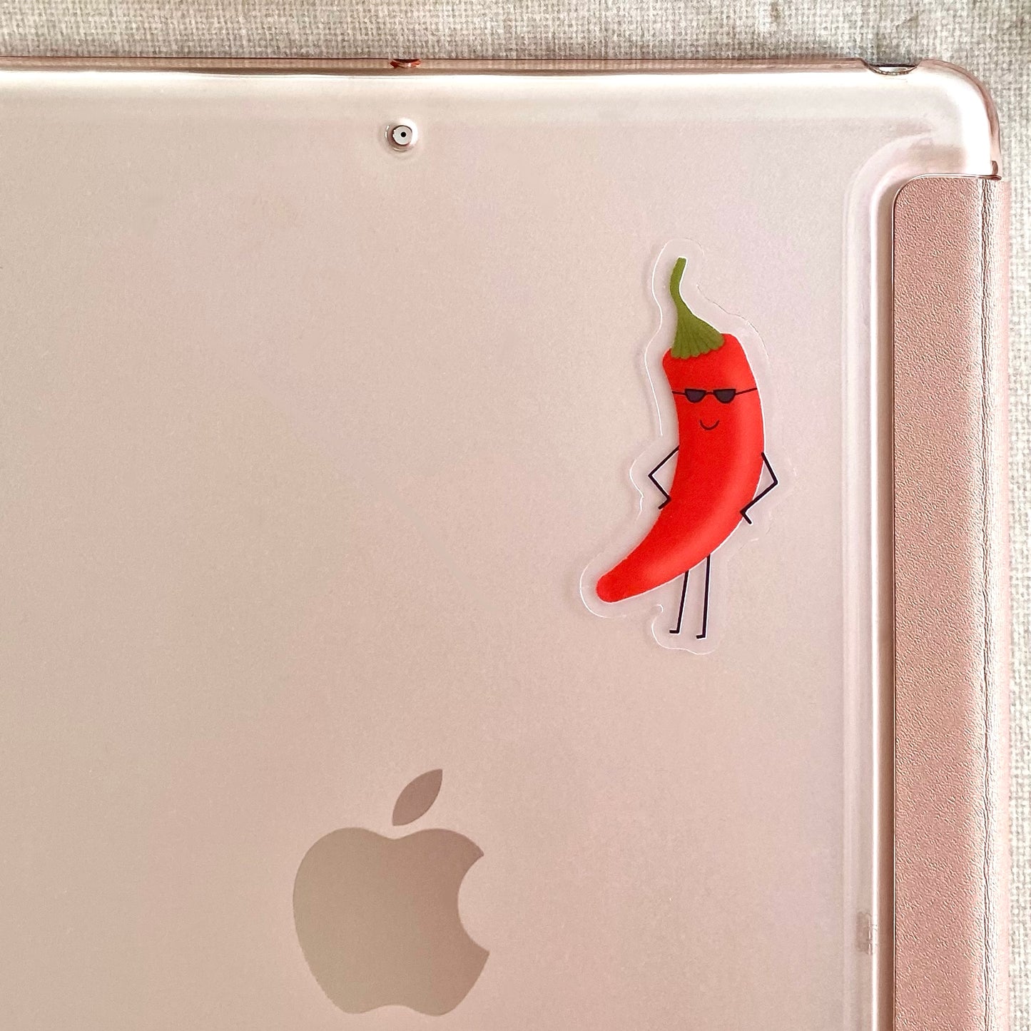 Transparent vinyl sticker with a cartoon red chili pepper with sunglasses stuck to the back of a tablet