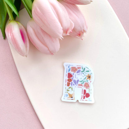 Decorative letter 'R' sticker with floral design on a white background