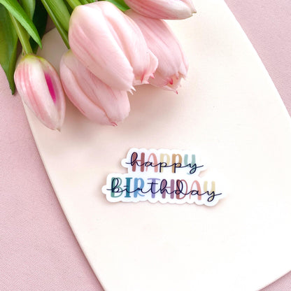 Colourful transparent 'Happy Birthday' sticker on a white background with pink tulips