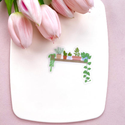 A transparent vinyl sticker with an illustration of a wooden shelf with potted plants on a white background