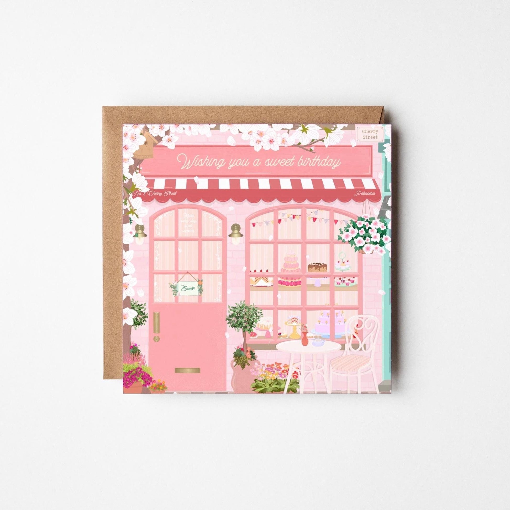 Card with a pink bakery illustration and 'Wishing you a sweet birthday' text on a brown envelope.