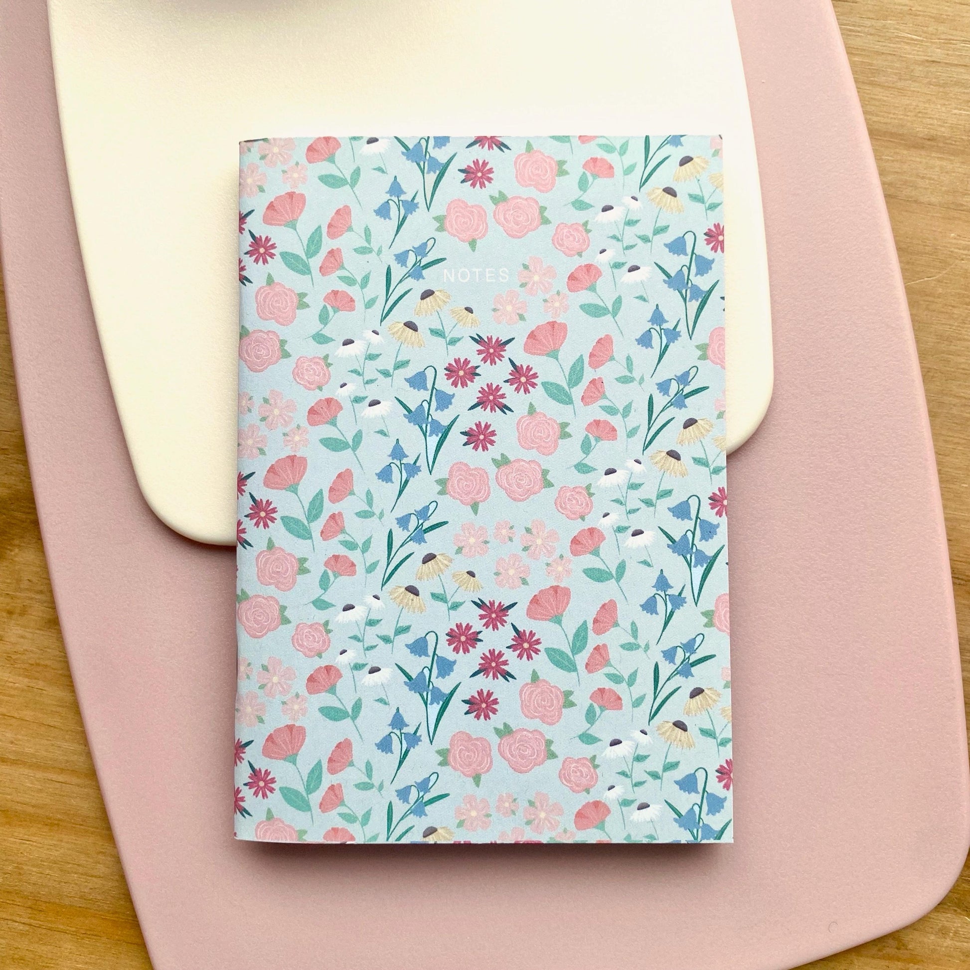 Floral patterned notebook on a pink surface