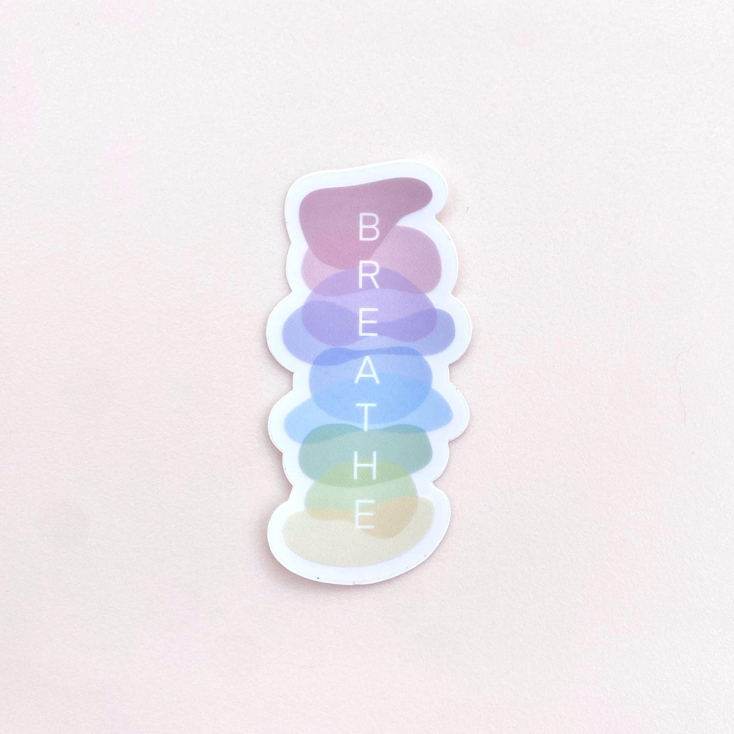 Sticker with a stack of pastel-coloured stones with 'BREATHE' text on a white background