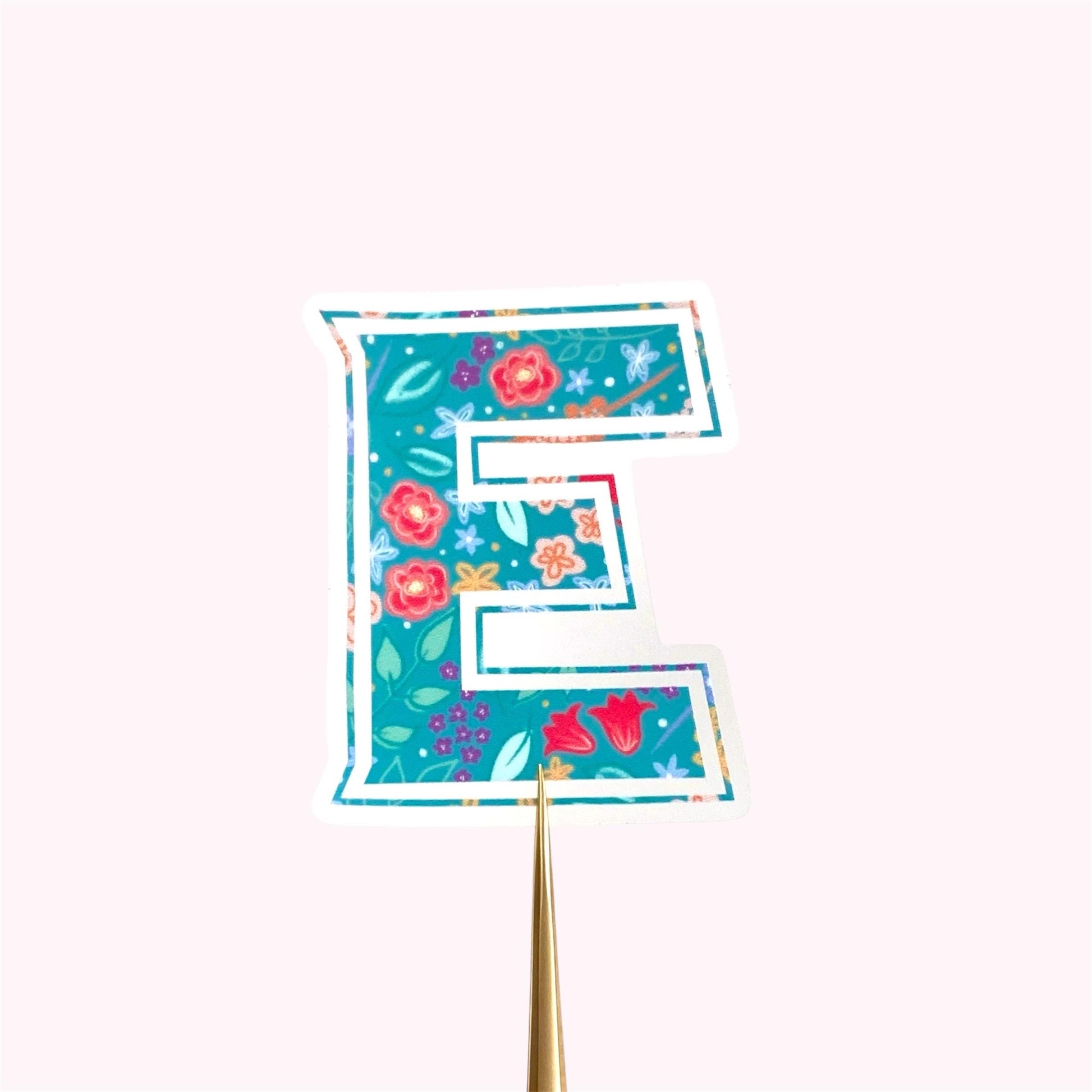Decorative letter 'E' sticker with floral design on a white background