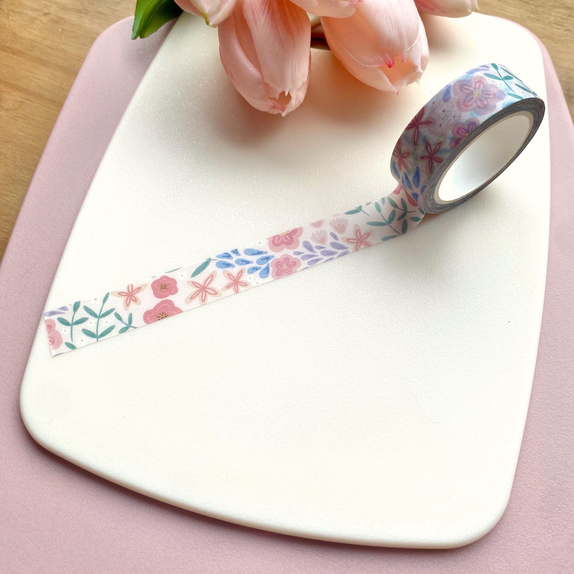 Floral-patterned tape on a white surface with pink tulips