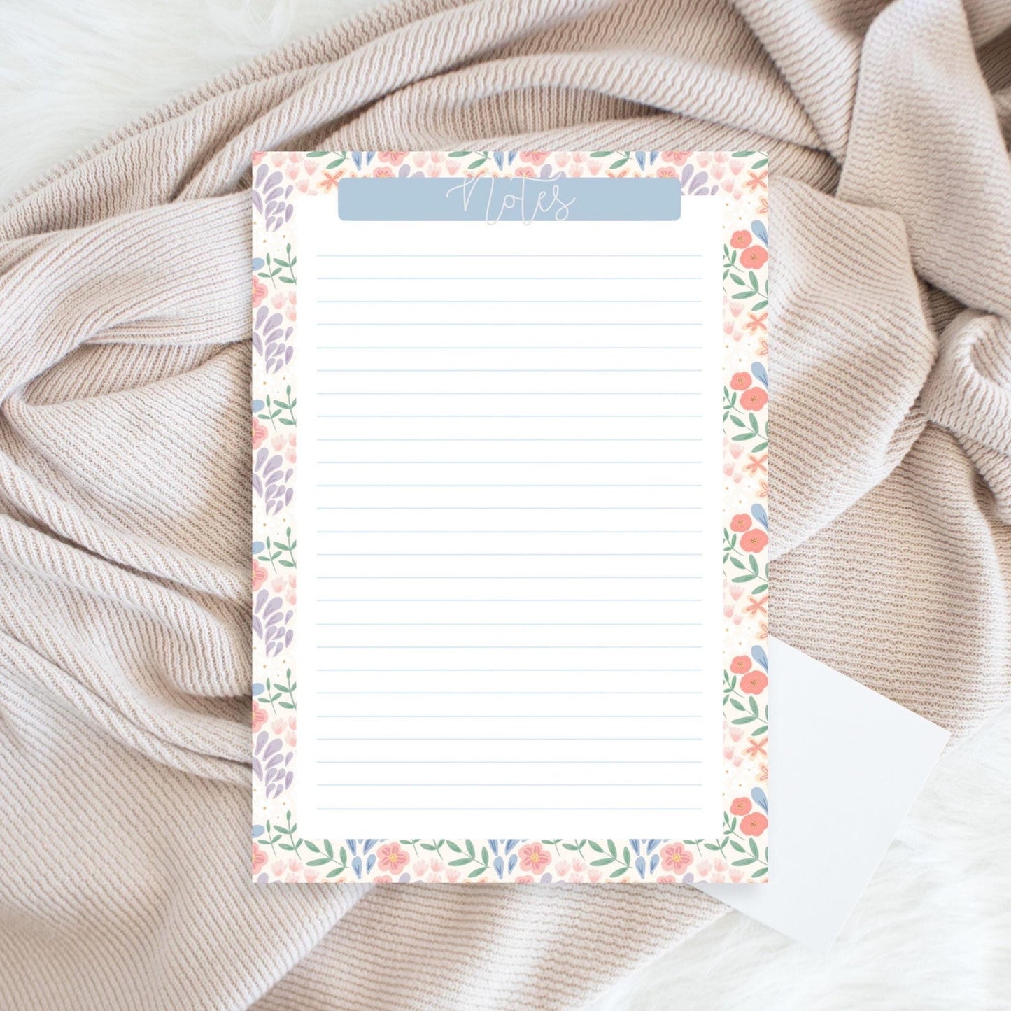 Floral notepad on a textured fabric background