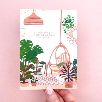 Postcard with a design of plants, a hanging chair, and a lamp on a pink background.