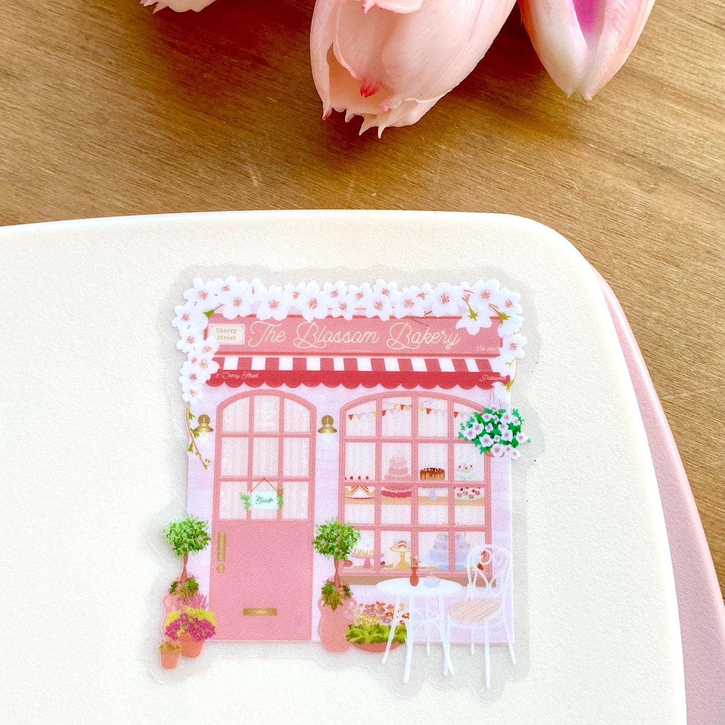 Sticker of a pink bakery with 'The Blossom Bakery' text on a white background.