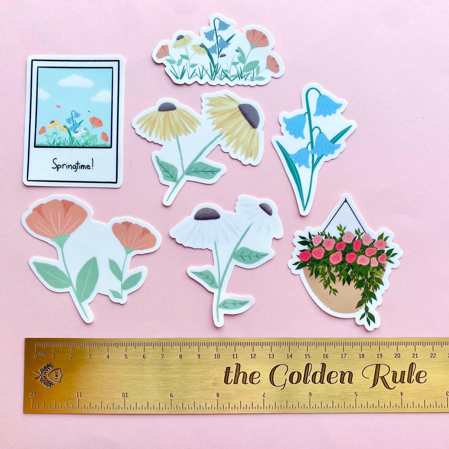 Set of floral stickers on a pink background with a ruler for scale.