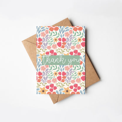 Floral card with 'thank you' text and a brown envelope on a white background