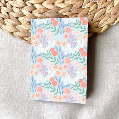 Floral patterned notepad on a woven mat