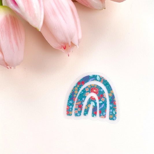 Decorative rainbow sticker with floral patterns on a white background