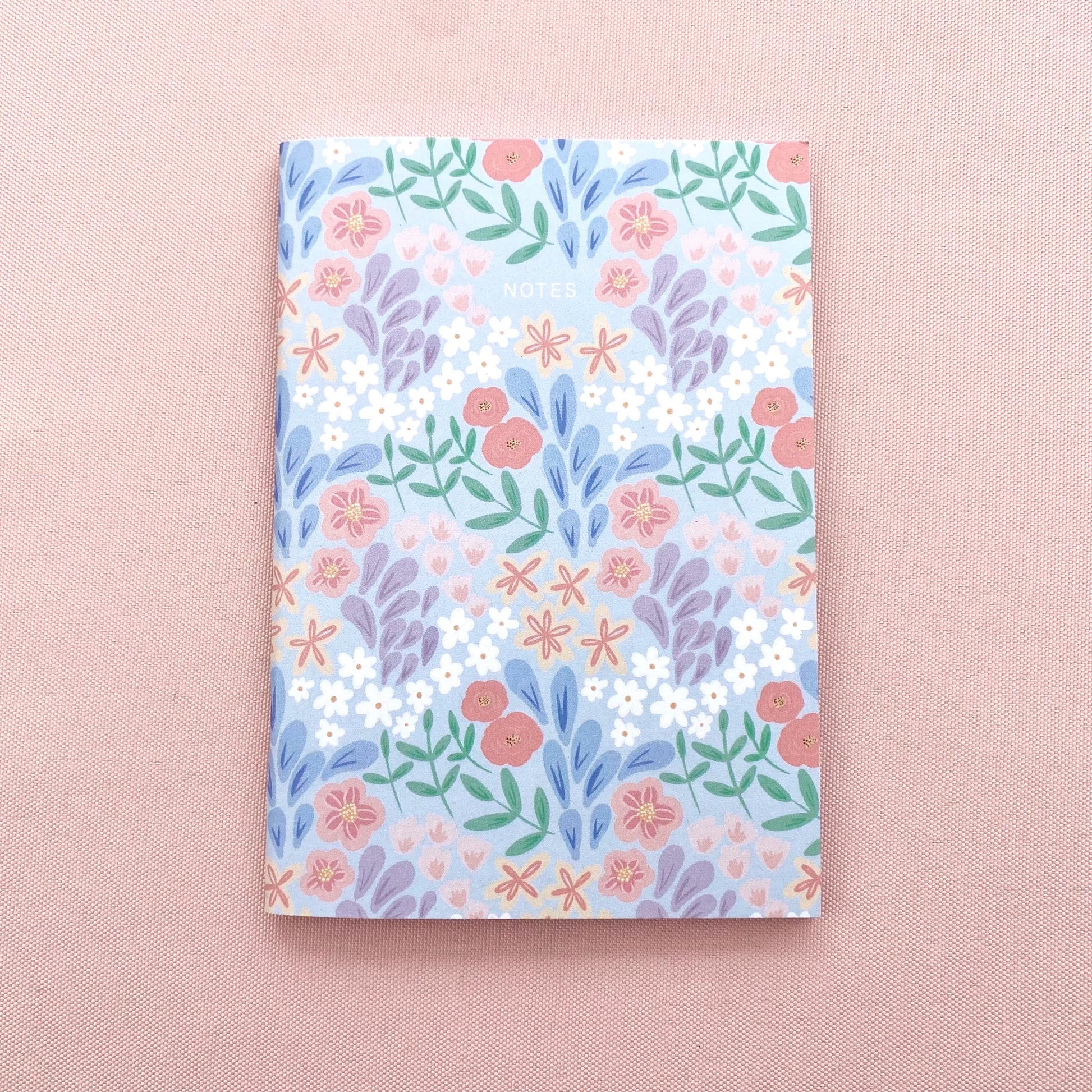 Floral patterned notebook on a pink background
