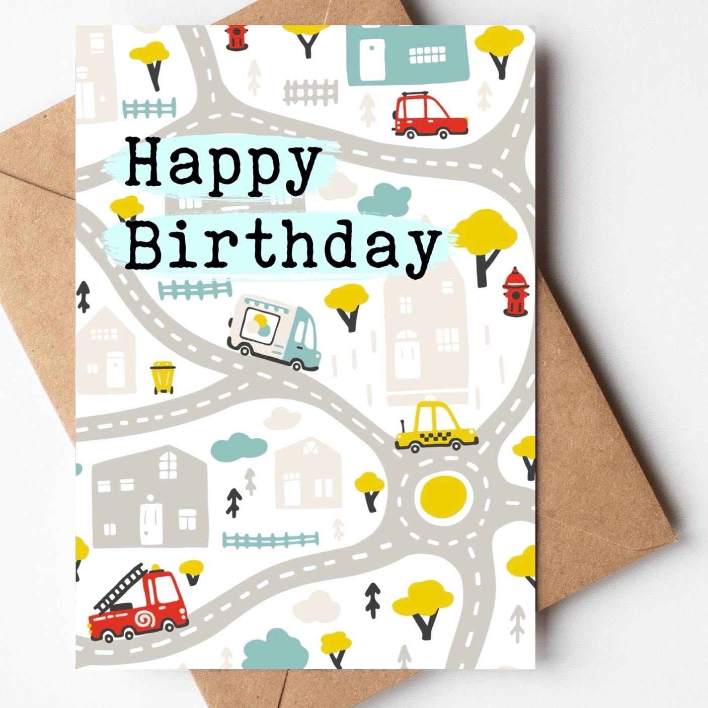 Birthday card with city street design and 'Happy Birthday' text, featuring a brown envelope.