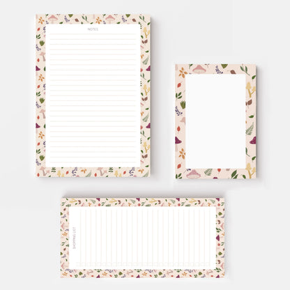 Three floral notepad sheets with lined writing areas and decorative borders with autumnal mushroom and leaves, arranged on a light grey background.