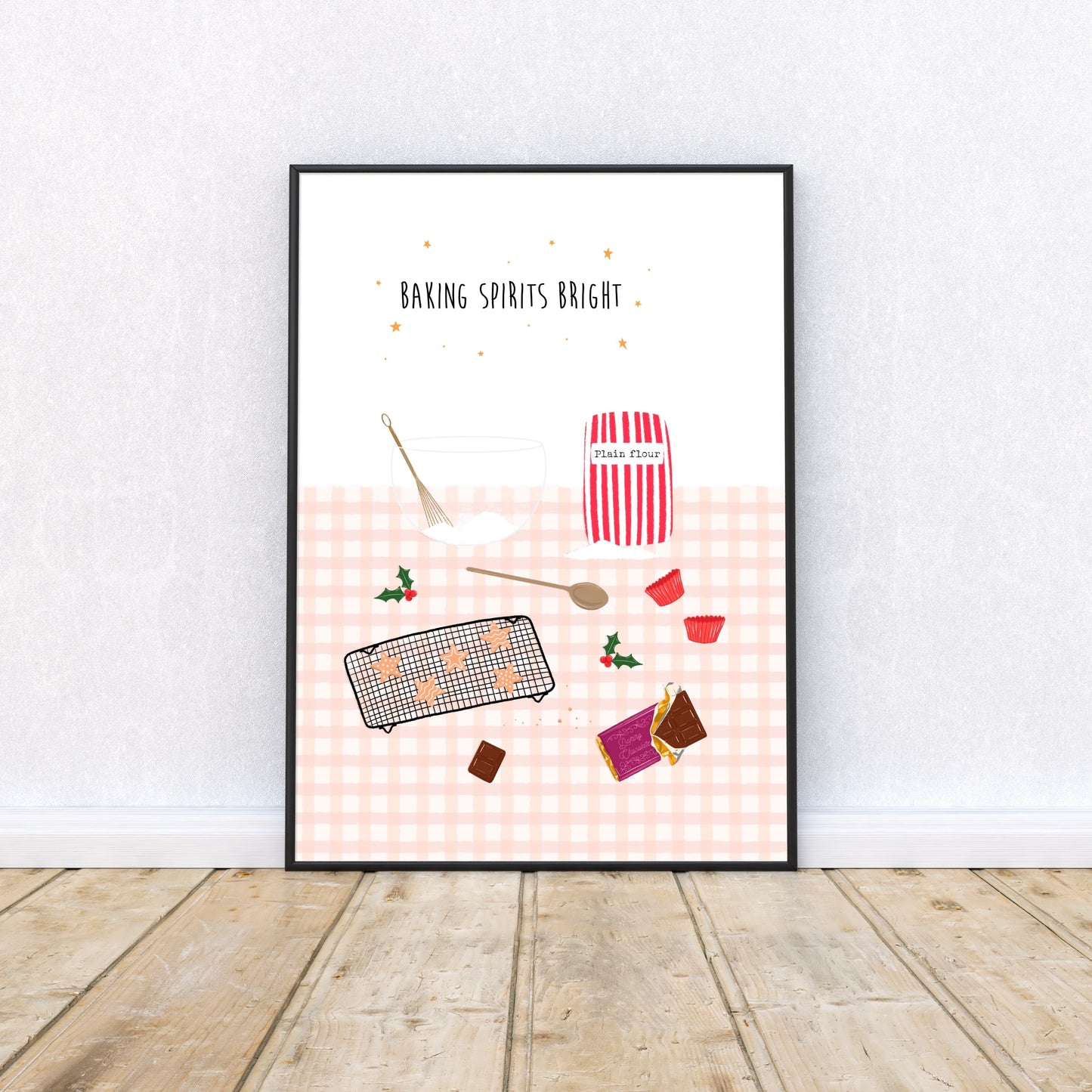 Framed artwork with pink Christmas baking-themed illustrations on a white wall.