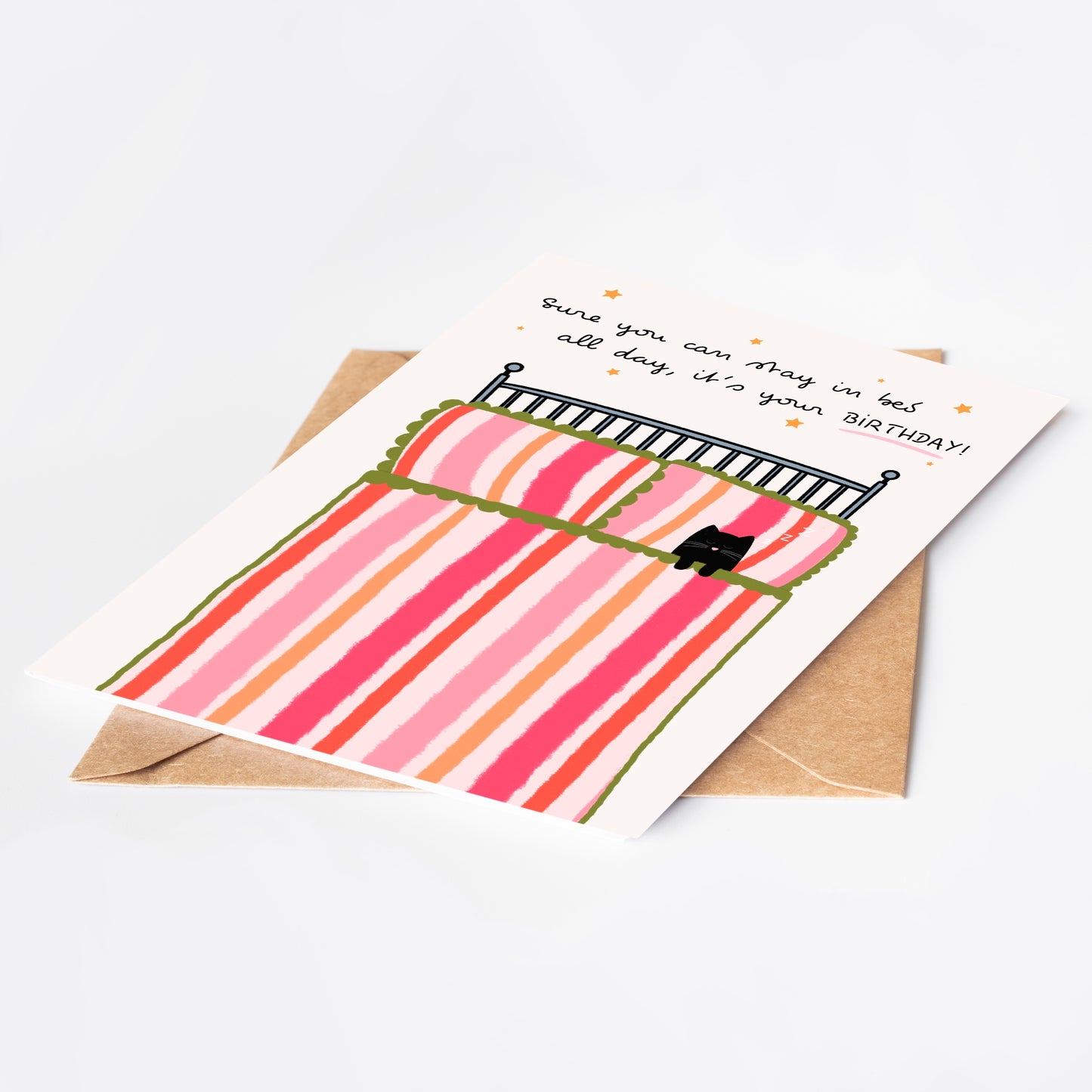 Greeting card with a cartoon pink bed with a black cat and text on a white background