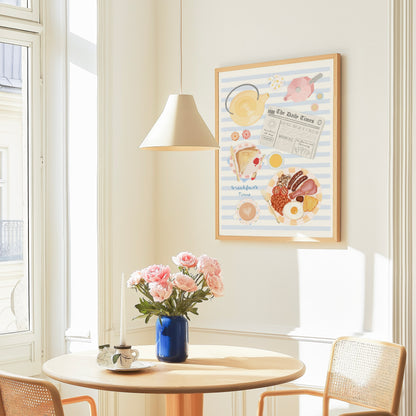 Room interior with a table, chairs, and a vase of flowers under a framed breakfast themed illustration picture on the wall.