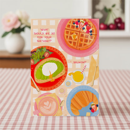 Colourful birthday card with brunch-themed illustrations on a checkered tablecloth.
