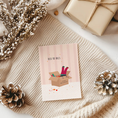 Greeting card with 'Deck the Halls' text and Christmas-themed illustration on a textured surface with decorative elements.