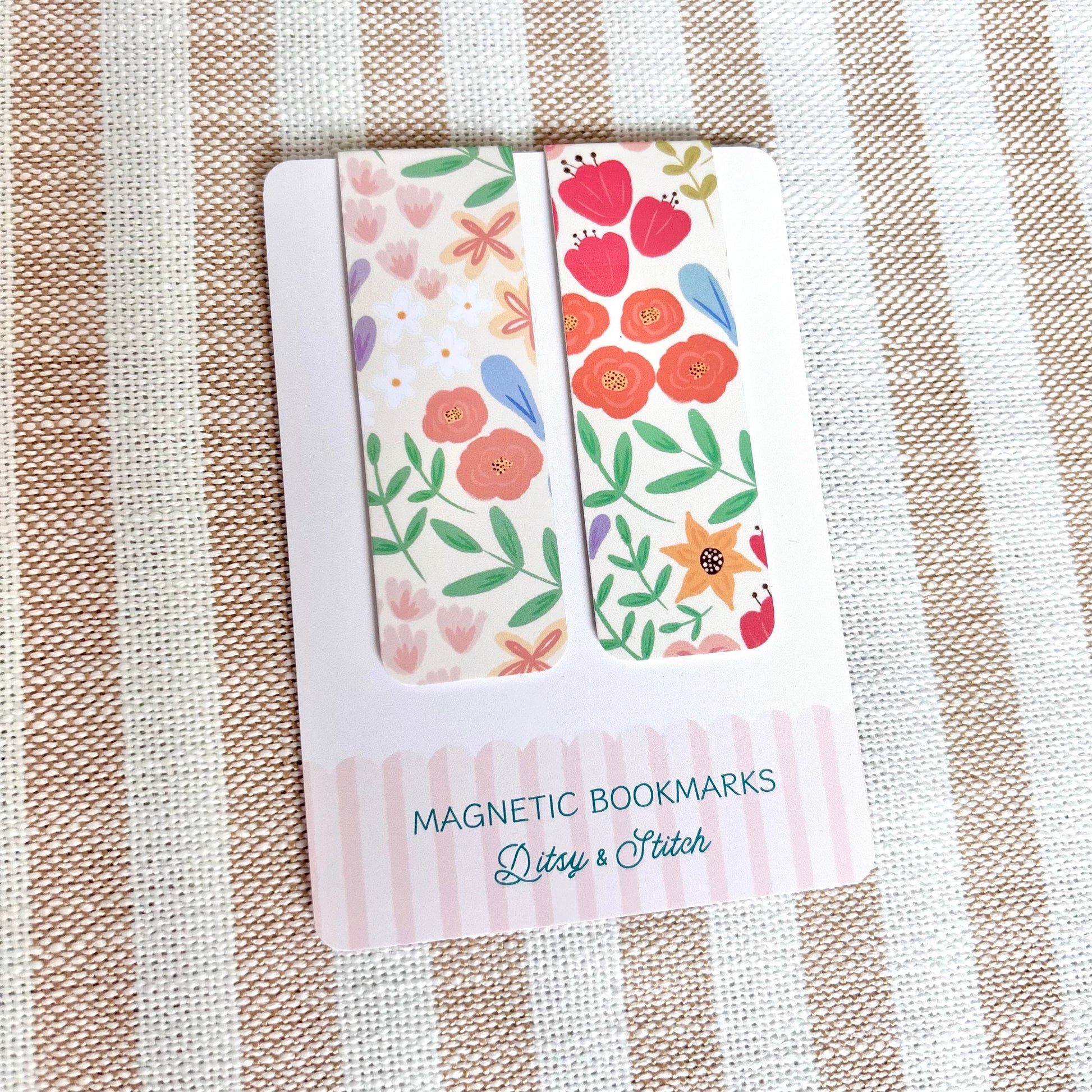 Floral magnetic bookmarks in packaging on a striped fabric background