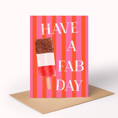 A greeting card with a brown kraft envelope, featuring a pink and orange striped background, an ice lolly, and the text 'HAVE A FAB DAY' in white.