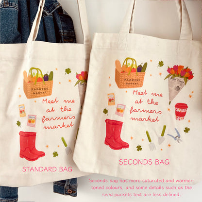 Two canvas tote bags displayed side by side, labelled STANDARD BAG and SECONDS BAG, with printed illustrations of a basket of produce, red rain boots, flowers, gardening tools, and handwritten text reading 'Meet me at the farmers market.'.