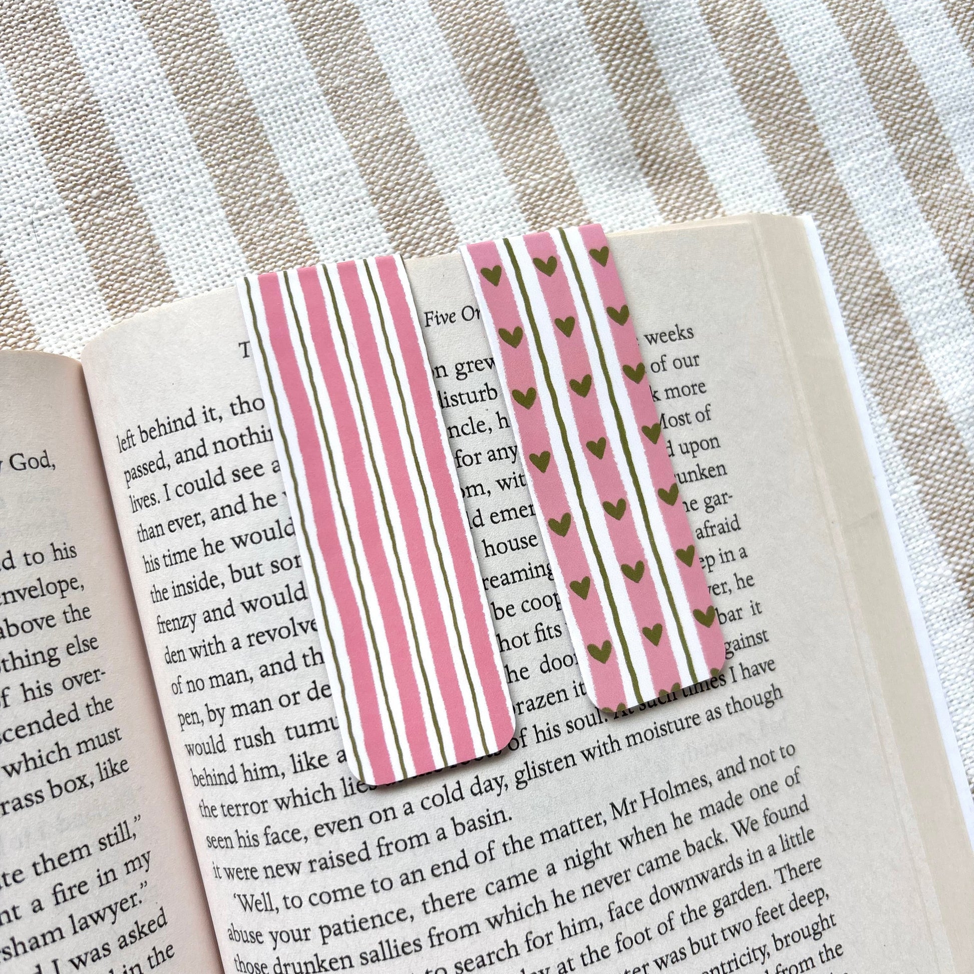 Book with decorative magnetic bookmarks on a striped fabric background