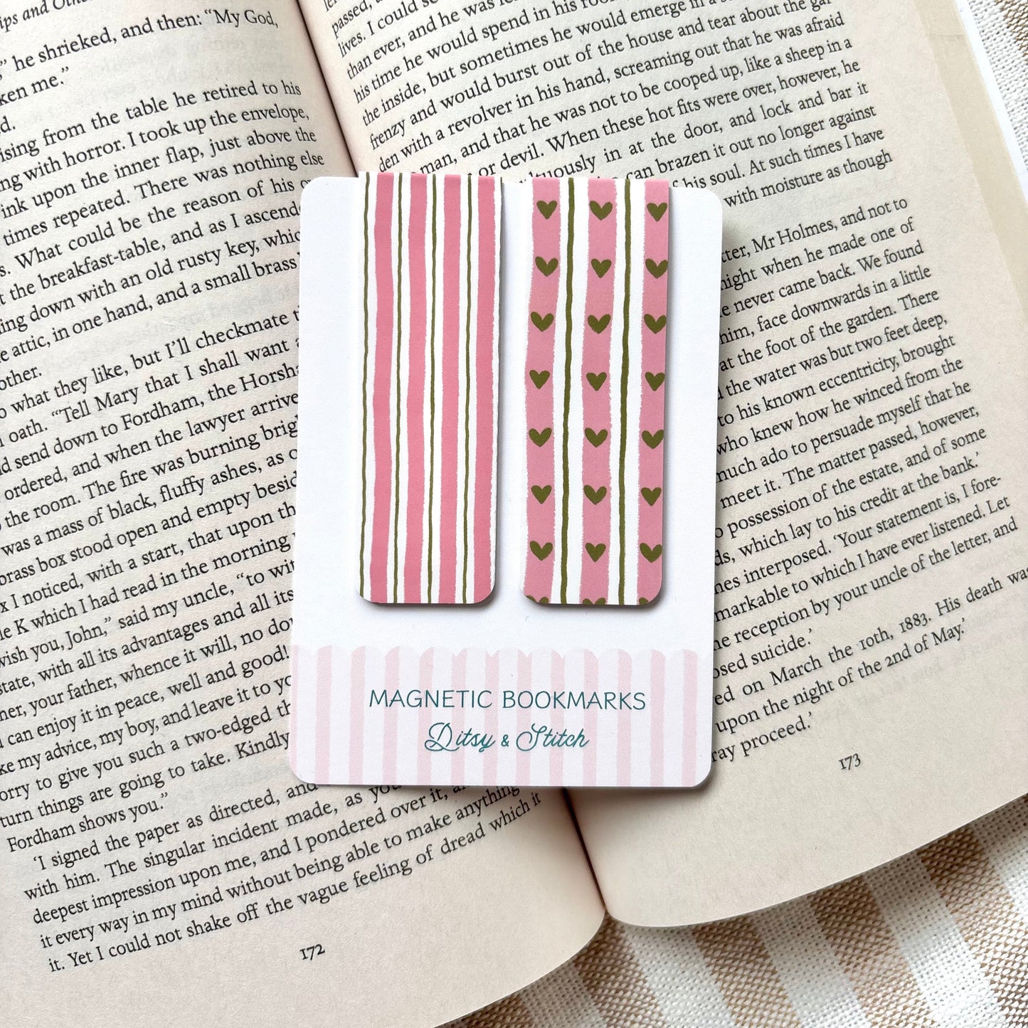 Magnetic bookmarks with striped and heart designs on a book